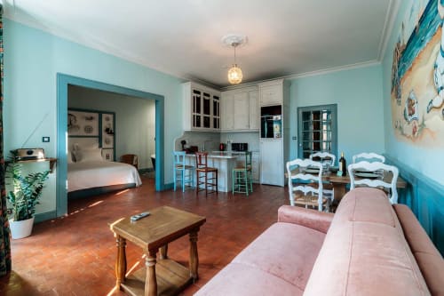 Studio Mes à Moi à Pézenas : murs turquoise, canapé rose, cuisine et chambre dans une maison d'hôtes de la Côte d'Azur