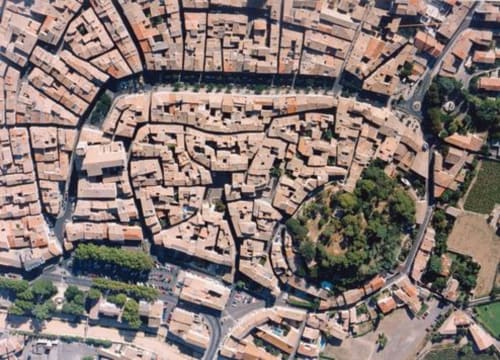 Vue aérienne du centre historique de Pézenas avec toits en terre cuite, ruelles sinueuses, rivière et Mes à Moi Pézenas