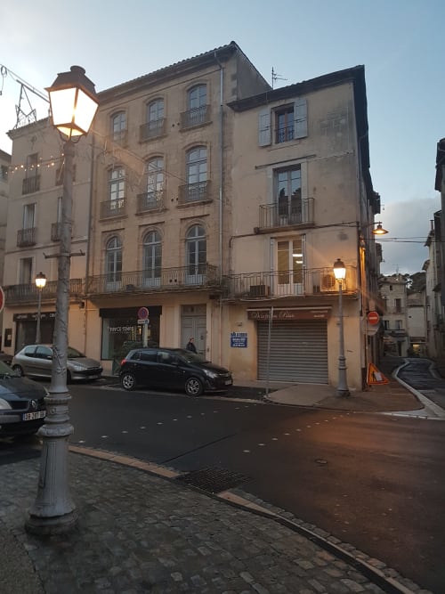 Mes à Moi Pézenas, gîte au crépuscule : bâtisse historique illuminée par des réverbères dans la vieille ville médiévale française