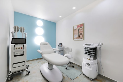 Salle de soin spa moderne chez Mes à Moi Pézenas avec fauteuil blanc, équipements professionnels de soins et accents bleus