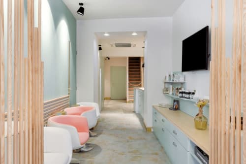 Couloir spa contemporain du Mes à Moi Pézenas avec fauteuils de soin rose et séparateurs en bois