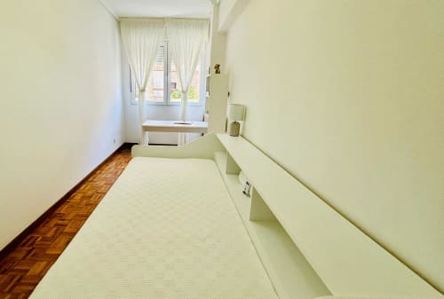 Habitación espaciosa en apartamento Breixo, Baiona con camas individuales, suelo de madera y ventana con vistas a la ciudad