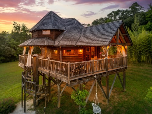 Luxe boomhut aan Domaine De Campagnac in Carsac-Aillac met verlichte houten interieur, rond terras en zonsondergang