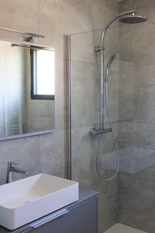Bagno moderno con doccia a pioggia, lavabo bianco e specchio nella Villa Grignan, La Maison D'ambrine a Chamaret
