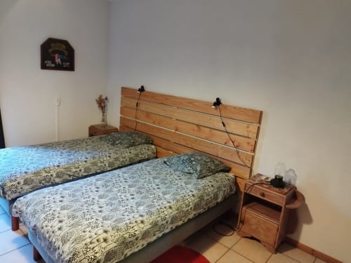 Camas gemelas con colchas estampadas y cabecero de madera en L'étape Du Fanfoué BnB en Chamrousse