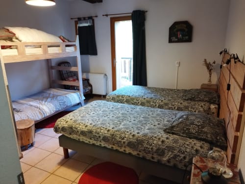 Spacious bedroom at L'étape Du Fanfoué in Chamrousse with bunk beds, twin beds, balcony access, and mountain views