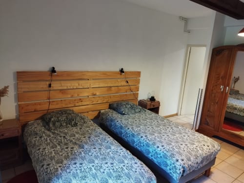 Dos camas gemelas con colchas estampadas y cabecero de madera en la habitación Morille de L'étape Du Fanfoué, Chamrousse