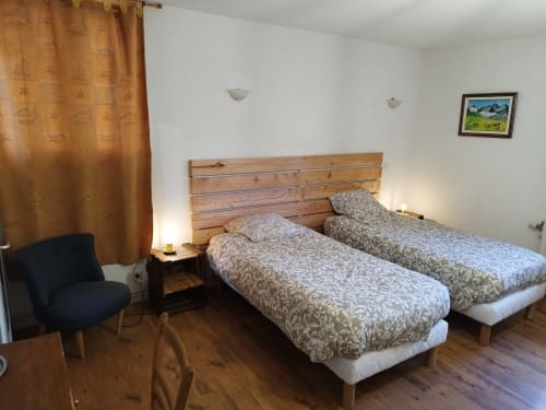 Twin beds in Chanterelle room at L'étape Du Fanfoué, Chamrousse with mountain view and wooden furnishings