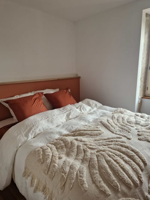 Chambre Maisonaurinko B&B à Thénon : tête de lit couleur rouille, literie blanche, plaid beige texturé, oreillers terracotta