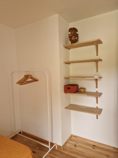 Coin lumineux de la chambre du Maisonaurinko B&B avec étagères en bois, portant blanc et parquet