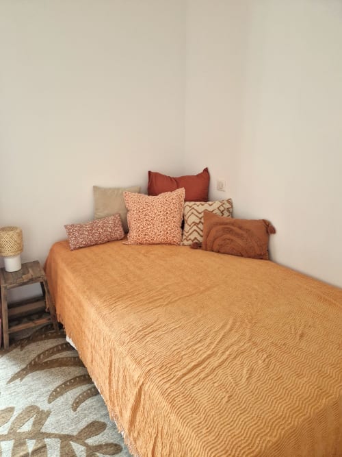 Chambre douillette à la Maisonaurinko B&B à Thénon, avec linge de lit en terre cuite et coussins décoratifs