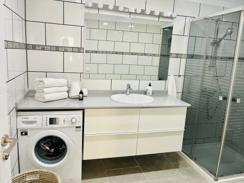 Modern bathroom at Sunset ocean view hotel in Arguineguín with white subway tiles, vanity sink, walk-in shower, and washing