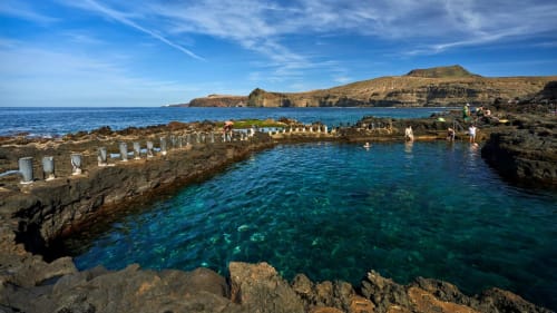 Natural saltwater pools with turquoise water and rock formations in Arguineguín, Spain coastal landscape