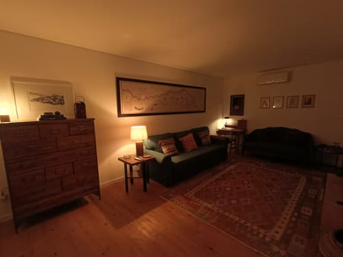 Sala aconchegante com sofá, móveis de madeira e obras de arte emolduradas na quinta Quinta do Fraguil, no Vale do Douro