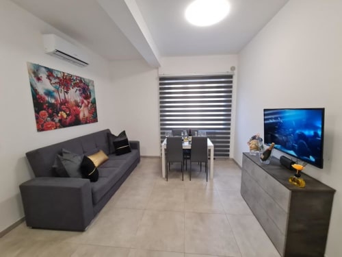 Apartman Raymihome u Torinu sa crnom sofom, blagovaonom, plazma TV-om i modernim namještajem sa prugastim roletama