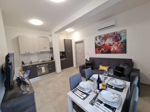 Moderni apartman u Torinu s otvorenom kuhinjom, blagavanom i crnom sofom, suvremenih namještaja