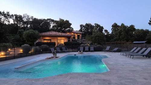 Villas Lantana pool area at dusk with illuminated villa, lounge chairs, and turquoise swimming pool in Lecci, Corsica