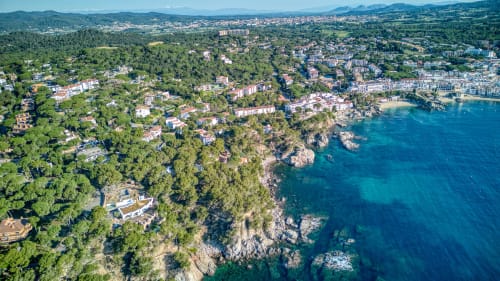 Vista aèria de la localitat costanera de Palafrugell amb penya-segats mediterrani, bosc de pins i aigües turqueses