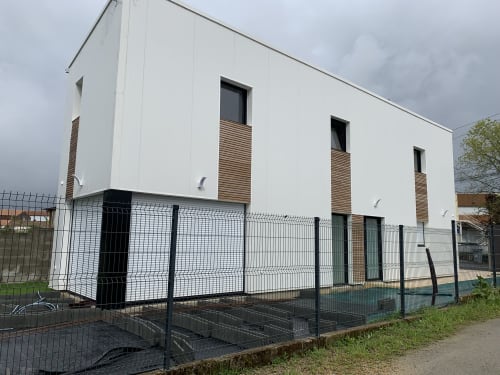 Maison d'hôtes moderne blanche La Maison Blanche à Bouguenais avec volets en bois et clôture noire