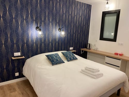Camera da letto moderna presso La Maison Blanche B&B a Bouguenais con carta da parati geometrica, biancheria bianca e illuminazione a sospensione