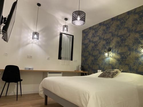 Chambre moderne à La Maison Blanche B&B à Bouguenais avec luminaires suspendus, mur d'accent motifs, bureau et literie blanche