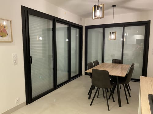 Salle à manger moderne avec portes vitrées à cadre noir à La Maison Blanche B&B à Bouguenais, France