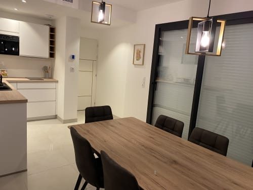 Cuisine ouverte et salle à manger modernes à La Maison Blanche B&B à Bouguenais, avec table en bois et chaises noires