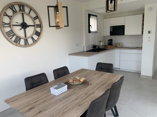 Cuisine et salle à manger modernes à La Maison Blanche B&B à Bouguenais avec table en bois et chaises noires