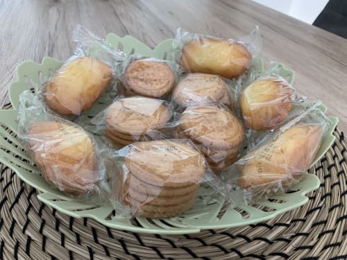 Assortiment de pâtisseries et pains individuellement emballés sur une assiette vert menthe à La Maison Blanche B&B à Bouguenais