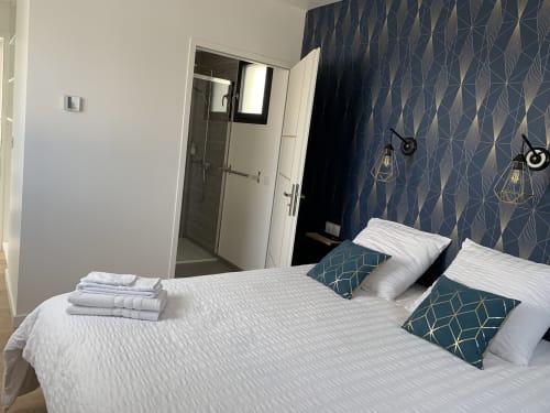 Camera moderna presso La Maison Blanche B&B a Bouguenais con doccia privata, carta da parati geometrica blu e biancheria bianca