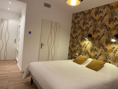 Camera da letto moderna presso La Maison Blanche B&B a Bouguenais con letto bianco, carta da parati a motivi dorati e arredamento contemporaneo