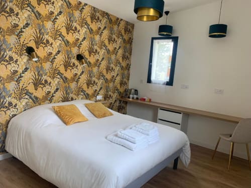 Camera moderna a La Maison Blanche B&B a Bouguenais con parete accent decorata, illuminazione sospesa e letto bianco