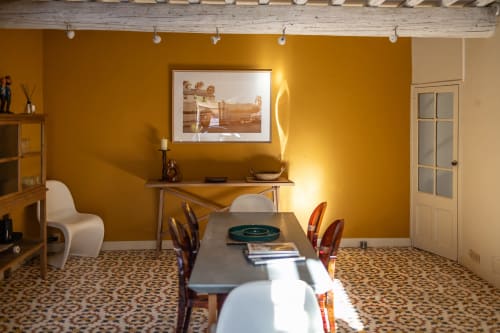 Chambre chaleureuse jaune moutarde au Prieuré Notre-Dame avec table à manger, bureau et décor moderne à Montfrin