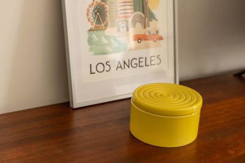 Yellow decorative box on wooden desk beside Los Angeles travel poster at Le Prieuré Notre-Dame in Montfrin