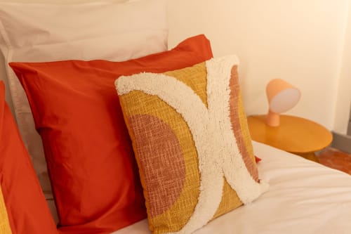 Colorful pillows on bed in Madeleine Room at Le Prieuré Notre-Dame, a charming bed and breakfast in Montfrin, France