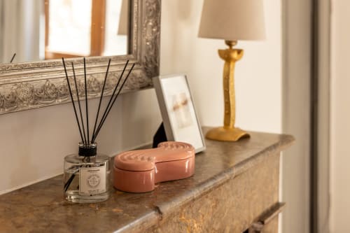 Elegant dresser in Madeleine Room at Le Prieuré Notre-Dame with reed diffuser, coral trinket box, and lamp