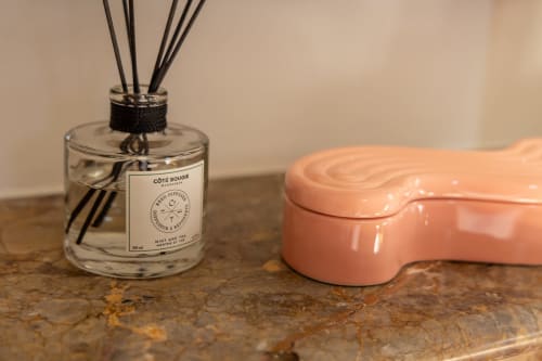 Côte Bougie reed diffuser and coral soap dish on rustic surface in Madeleine Room at Le Prieuré Notre-Dame