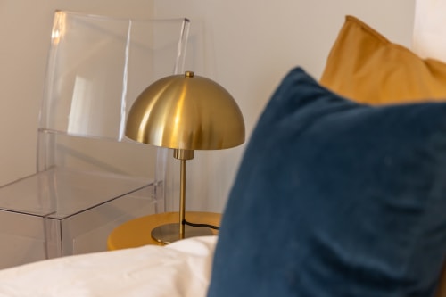 Lampe de bureau en laiton moderne à côté d'un organiseur en verre transparent, chambre Alphonse à Le Prieuré Notre-Dame, Montfrin