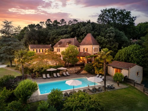 Zonsondergang bij Domaine De Campagnac in Carsac-Aillac met torens, zwembad en tuinen