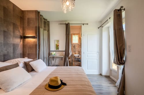 Ruime slaapkamer in Domaine De Campagnac cottage met eigen badkamer, elegant meubilair en uitzicht op de tuin