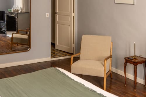 François Room at Le Prieuré Notre-Dame with upholstered chair, wooden side table, and hardwood floors in Montfrin
