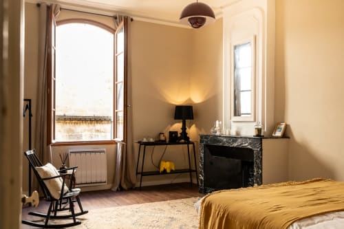 Elegant Louis Room at Le Prieuré Notre-Dame with golden walls, fireplace, and landmark views from open windows in Montfrin,