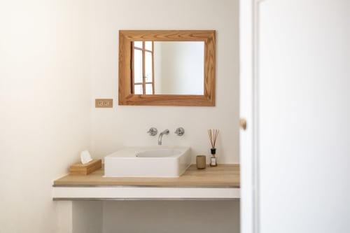 Modern bathroom sink with wooden mirror at Le Prieuré Notre-Dame in Montfrin, France
