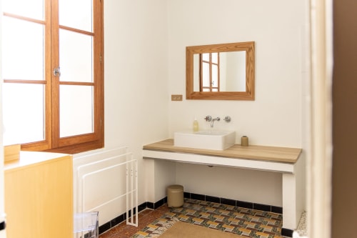 Modern bathroom in Louis Room at Le Prieuré Notre-Dame with vessel sink, wooden mirror, and patterned floor tiles