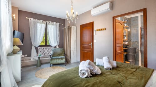 Slaapkamer Brume de Rêve in Domaine De Campagnac in Carsac-Aillac met groen beddengoed, witte handdoeken, houten deuren en tuin