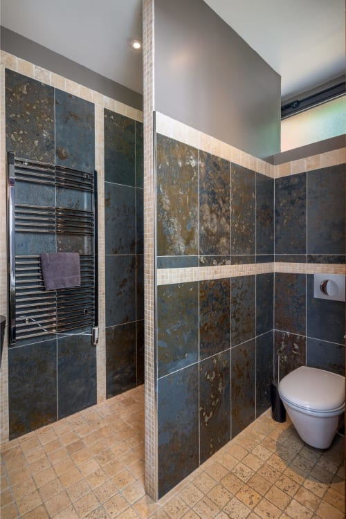 Moderne badkamer bij Domaine De Campagnac met leisteen wanden, regendouche, verwarmde handdoekrek en toilet