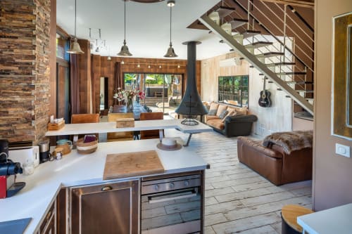 Moderne open woonruimte in Domaine De Campagnac met houtkachel, leren zitplaatsen en tuinuitzicht