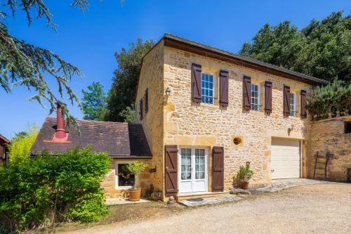 Stenen cottage op Domaine De Campagnac in Carsac-Aillac, Frankrijk met gesloten luiken en grindplein