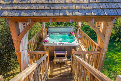 Houten terras met hot tub bij Domaine De Campagnac, een charmant bed & breakfast in Carsac-Aillac