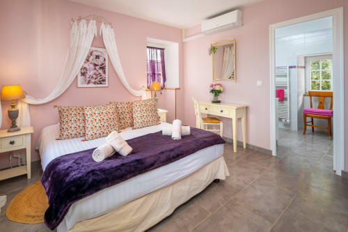 Roze slaapkamer in Gîte la Bergerie van Domaine De Campagnac, Carsac-Aillac met hemelbed en paarse fluwelen throw